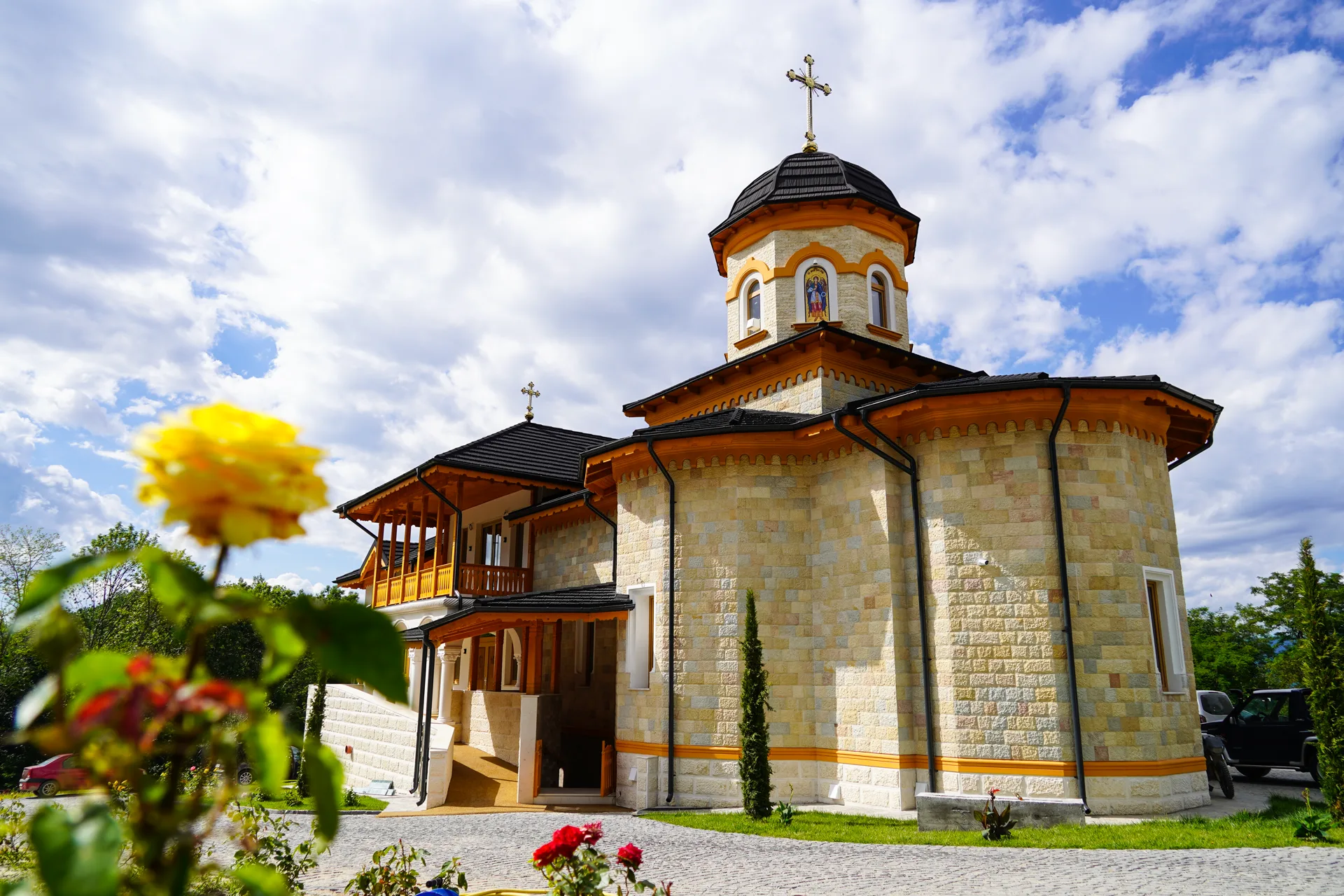 Biserica printre trandafiri galbeni, în prim plan