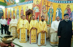 Sobor de preoți în veșminte aurii în biserica Schitului Nașterea Maicii Domnului Chilii, cu frescele sfinților pe fond de aur